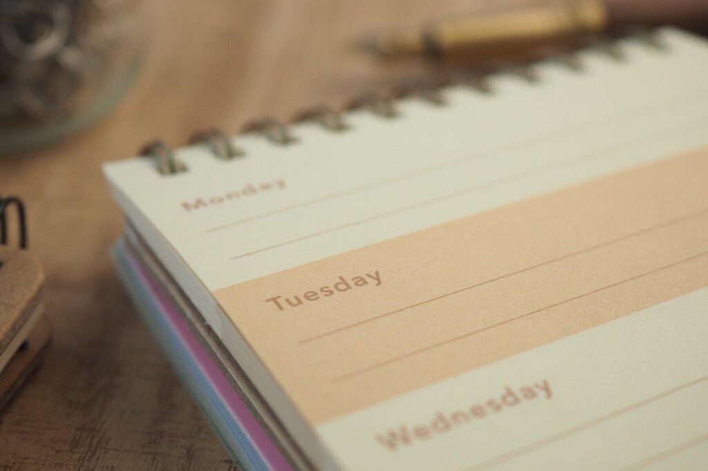 agenda-mom-weekly-planner-ouvert-sur-un-bureau-en-bois-pour-une-organi planifier sa semaine maman solopreneur