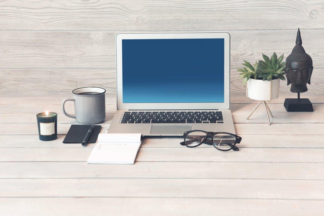 Espace de travail financier d’un freelancer moderne, avec ordinateur, calculatrice et documents pour simuler son salaire net.