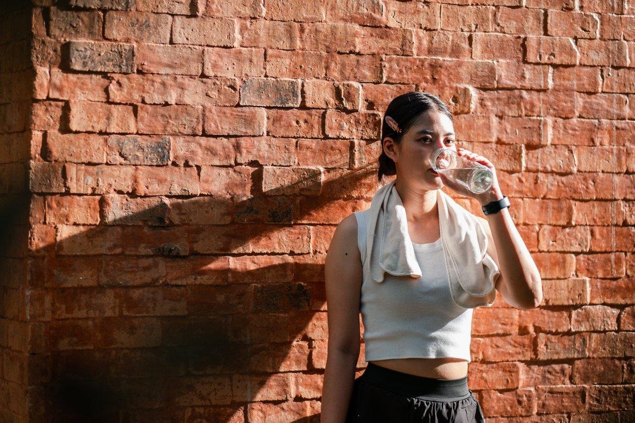 Routine matinale d'une entrepreneure dynamique : hydratation, lumière naturelle et énergie pour la journée.