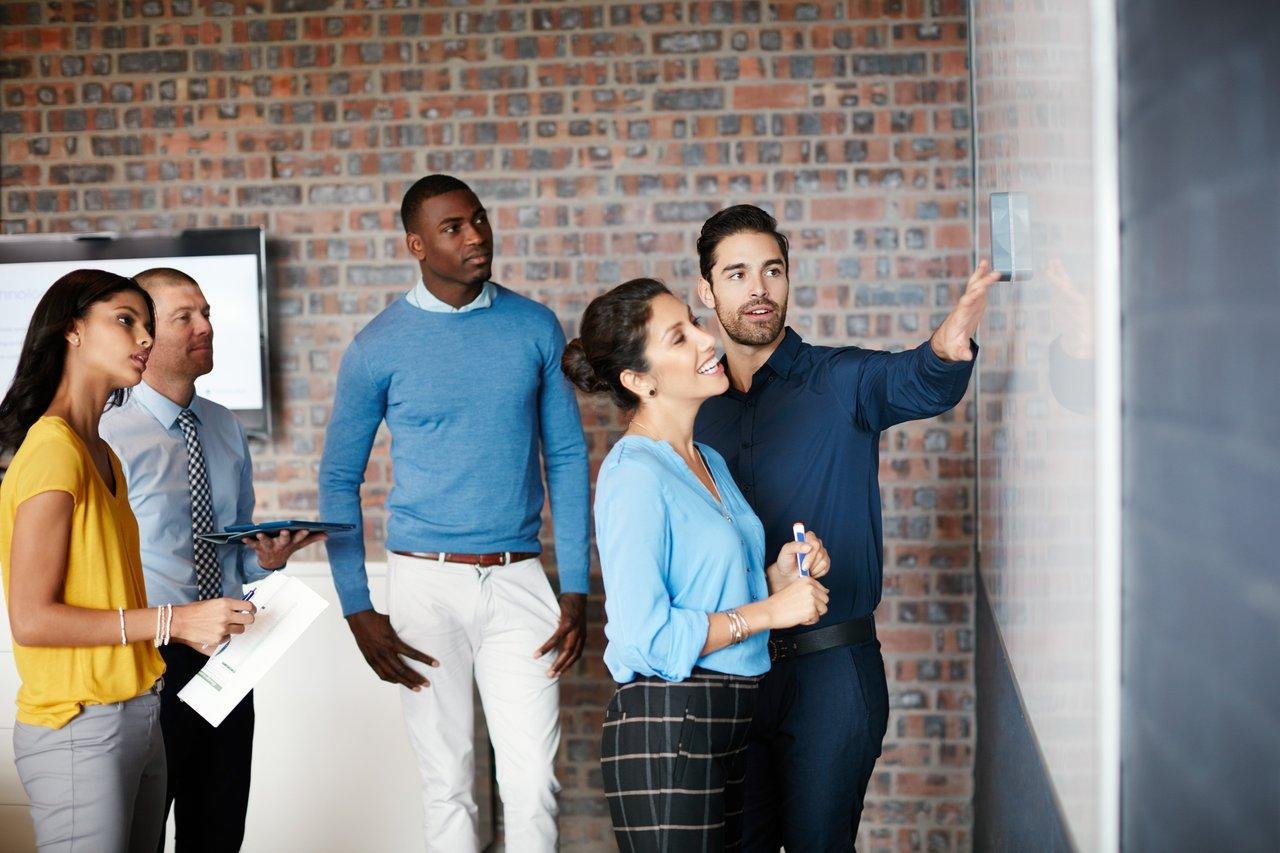 Une équipe de marketing en brainstorming autour d’un whiteboard illustrant l’importance des personae dans une stratégie digitale.